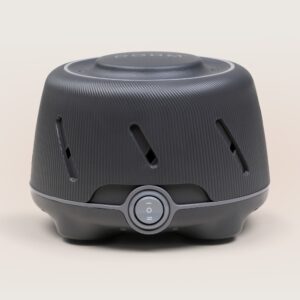 Front view of Dohm charcoal white noise machine showcasing ribbed housing and front power dial on a beige background