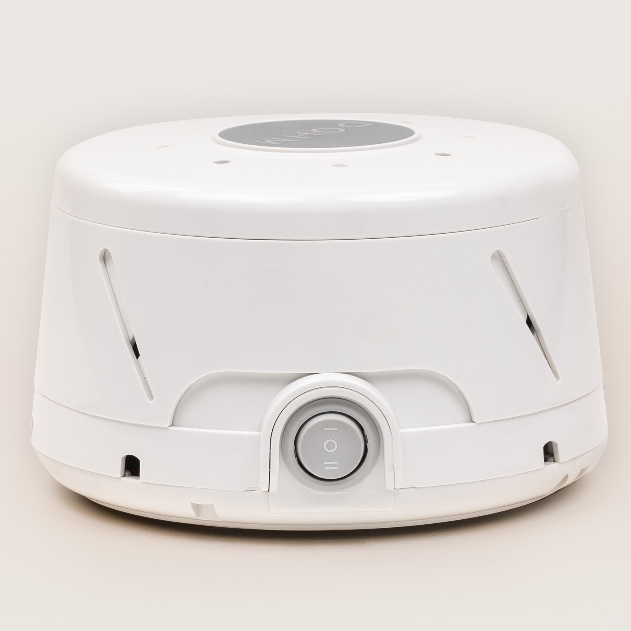 Three-quarter front view of Dohm Classic fan-based white noise machine showcasing side vents and central power dial on a light background