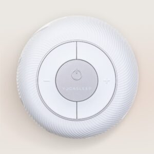 Front angle of Dohm Connect white noise machine highlighting diagonal vent slots and circular top control dial against a light beige background
