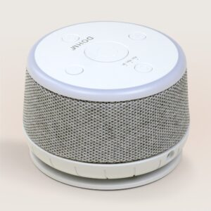 Three-quarter view of Dohm Nova sound machine showing gray fabric cover, white top controls, and night-light ring on neutral background