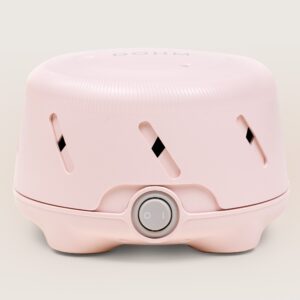 Front view of Dohm Uno pink white noise machine showing round power dial and diagonal vent slots on beige background