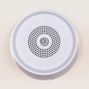 Top view of Dreamcenter sound machine showing speaker grille and dialable full color night light ring on beige background