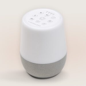 Top view of Duet sound machine showing control buttons on a white top and gray fabric speaker base on a beige background