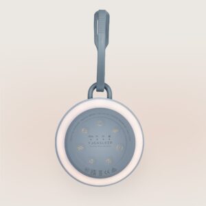 Top view of Hushh 2 showcasing illuminated night light ring, control icons, and hanging strap with blue linen background