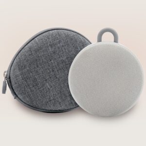 Front of Hushh 2 sound machine with travel case, showcasing compact circular speaker and fabric zip case on pale gradient background