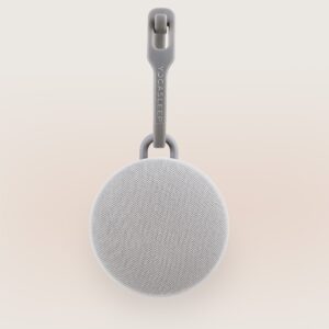 Front view of Hushh 2 portable sound machine with round speaker grille and Yogasleep hanging strap on a soft beige background