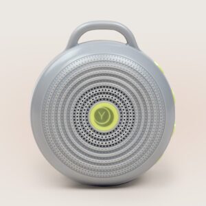Front view of Hushh portable sound machine with circular speaker grille, top handle, and yellow accent buttons