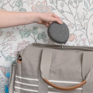 Person placing a gray Hushh baby sound machine into its protective travel case inside an open tote bag