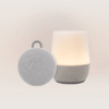 Front view of Duet and Hushh 2 bundle showing lit Duet lamp and Hushh 2 portable round speaker with loop on beige background
